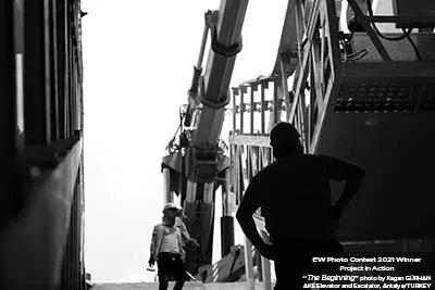 Black-and-white photograph of a technician in a lift shaft
